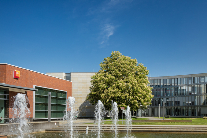 Exterior view of HPI Campus I with the lecture hall building, the main building, pond and fountain