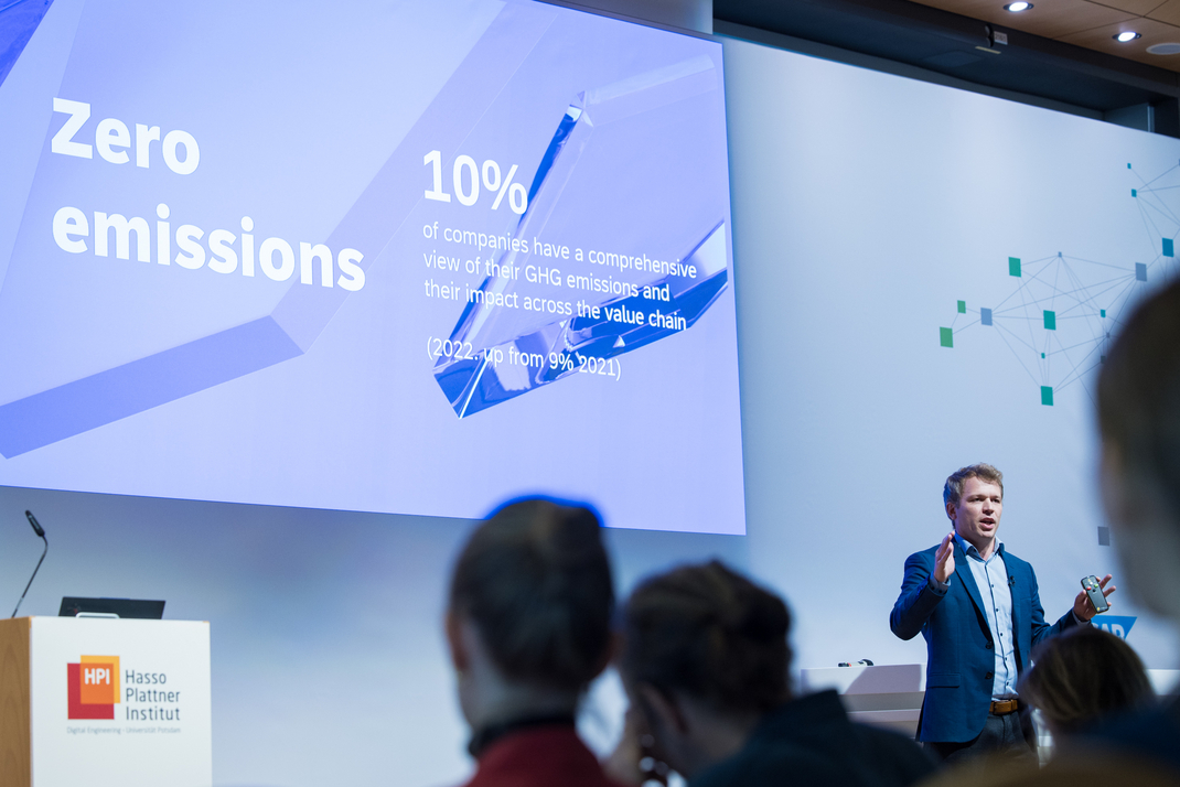 Dr. Philipp Herzig hält auf der Bühne eine Präsentation über nachhaltige KI-Innovationen