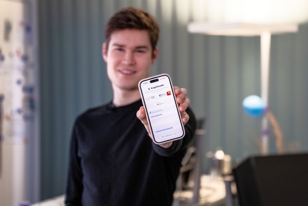 HPI-Student Kajo Kratzenstein zeigt den KI-Stimmenimitator auf seinem Smartphone