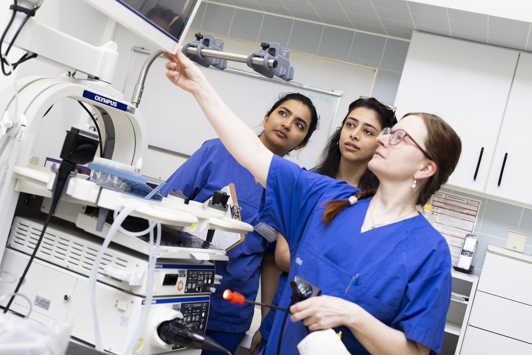 Head of Nursing Sylvia Ressler explains to the two HPI Master's students Eva Habib and Sharmy Ann James how a medical device works at the endoscopy ward.