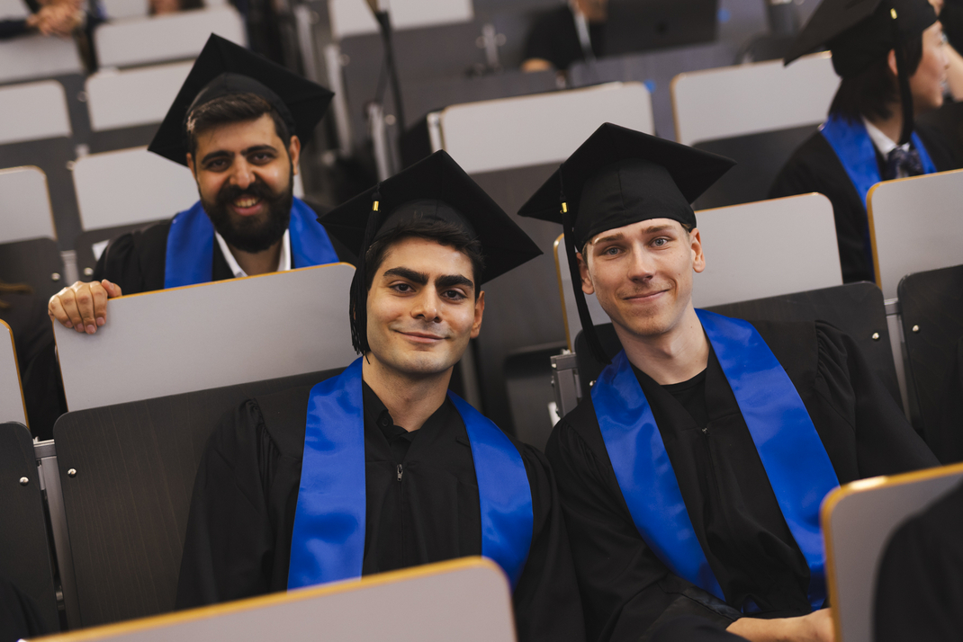 The photo shows proud graduates in the audience