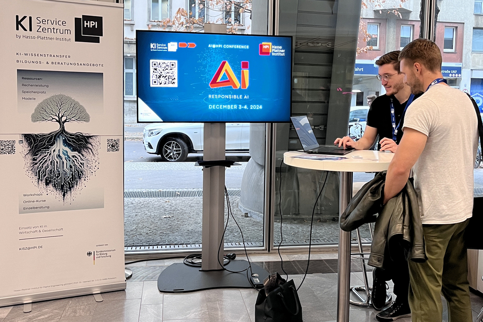 AI expert talking with a man at a standing table, background with AI Service Centre roll-up.