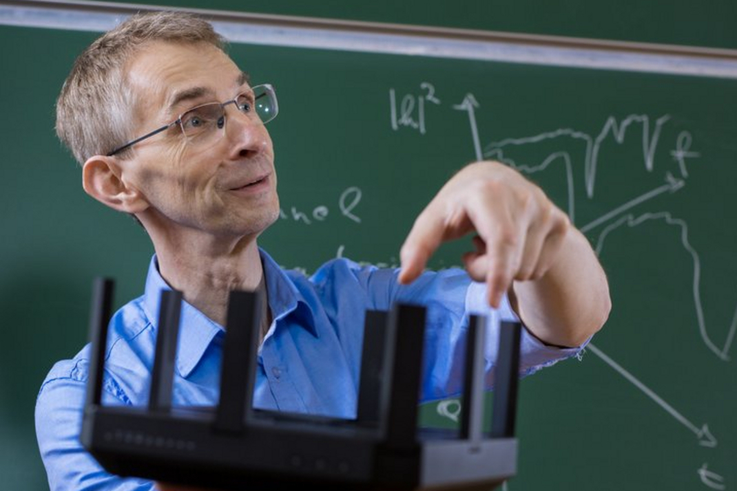 Prof. Dr. Holger Karl demonstriert während einer Vorlesung ein technisches Gerät.