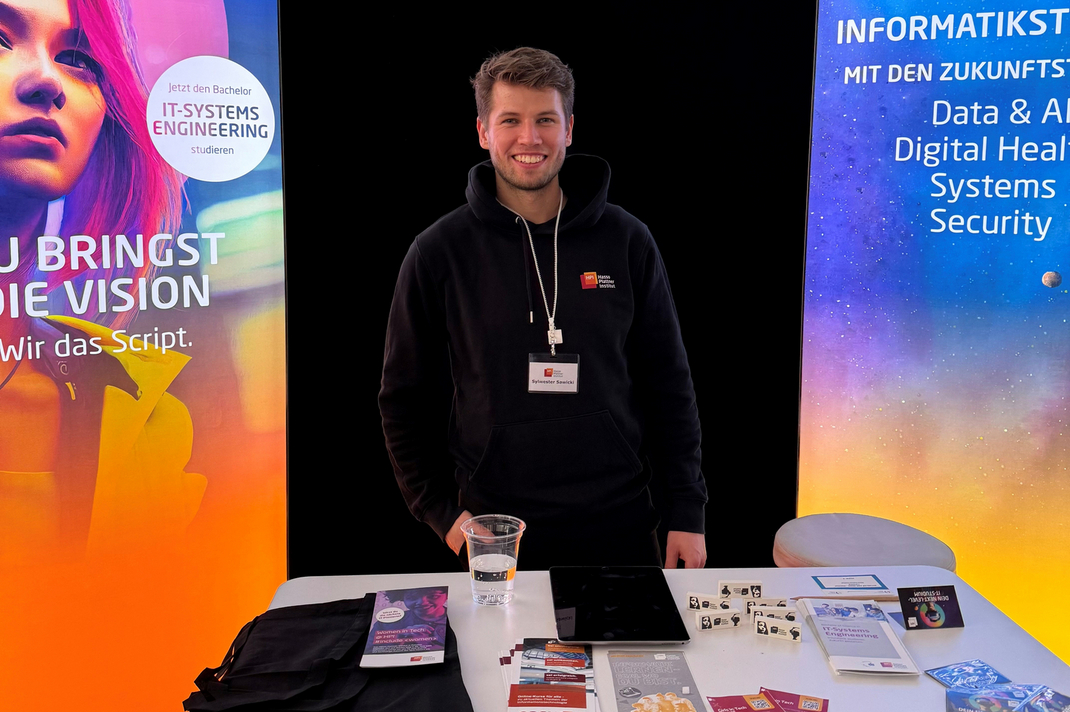 Masterstudent Sylwester Boldt steht an einem Messestand des Hasso-Plattner-Instituts