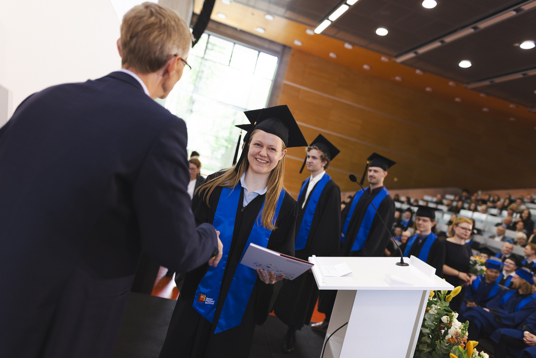 The graduates receive their diplomas one by one