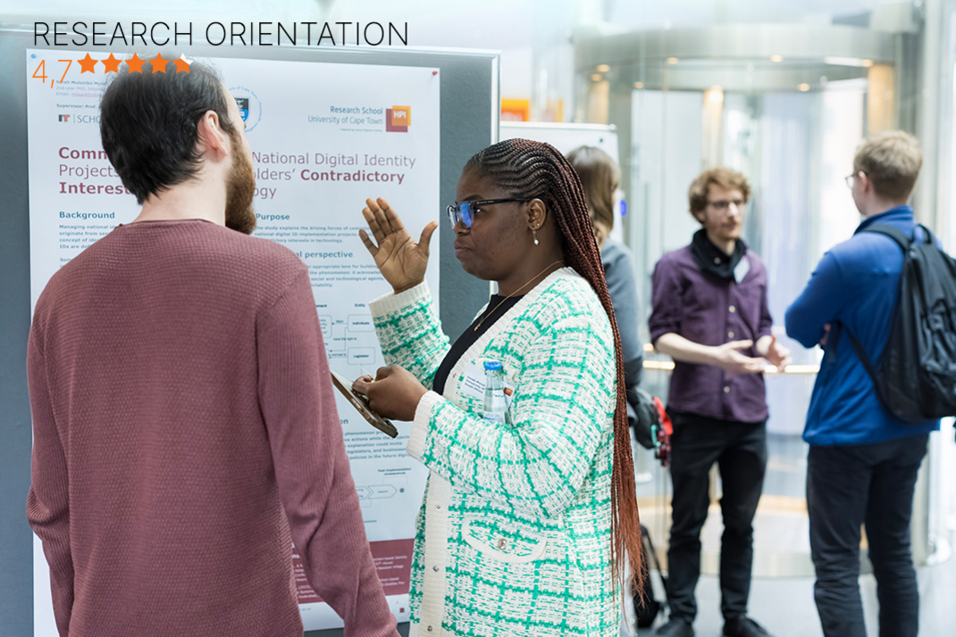 Two researchers from the Hasso Plattner Institute stand in front of a poster in the institute building and are engrossed in a discussion. In the background, other HPI researchers are talking. In the upper right corner of the picture is a purple seal of the current CHE master ranking. At the bottom of the picture is a bar with HPI's rating in the category “Research Orientation” (4.7 out of 5 stars).