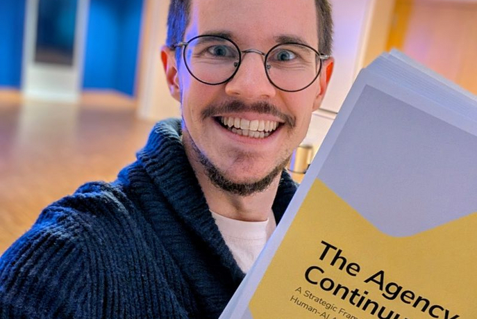 Samuel holds his new white paper up to the camera.