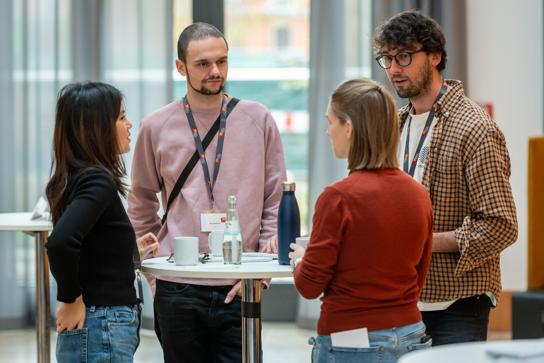 Members of the joint research project between HPI and the MIT Morningside Academy for Design, including Jan Enkmann and Cathy Fang, confer together at a table.