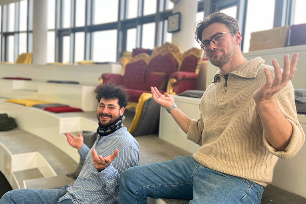 A photo of the two HPI doctoral students Roi Cohen and Konstantin Dobler. Both shrug their shoulders and raise their hands.