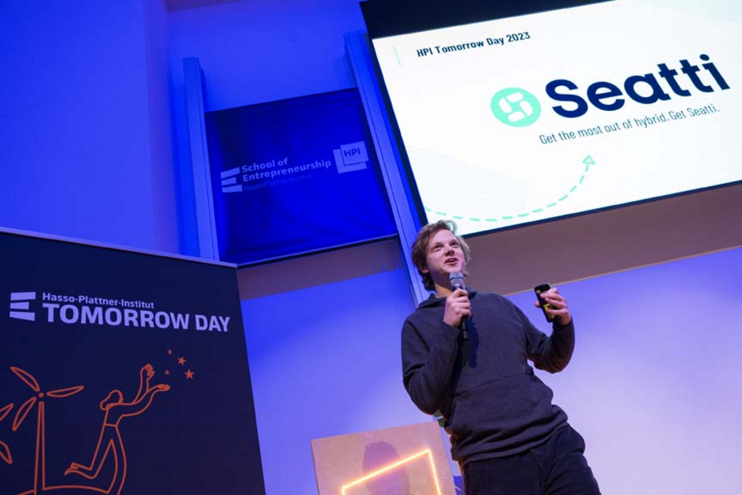 The startup team "Seatti" is being presented on stage.