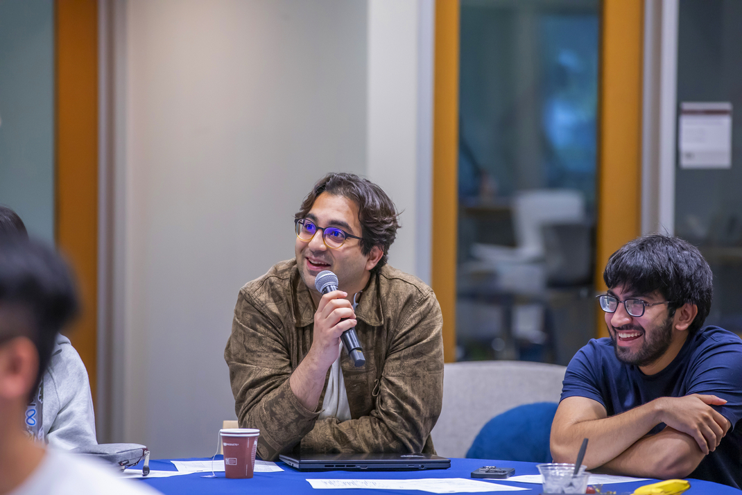 A workshop participant speaks into a microphone.