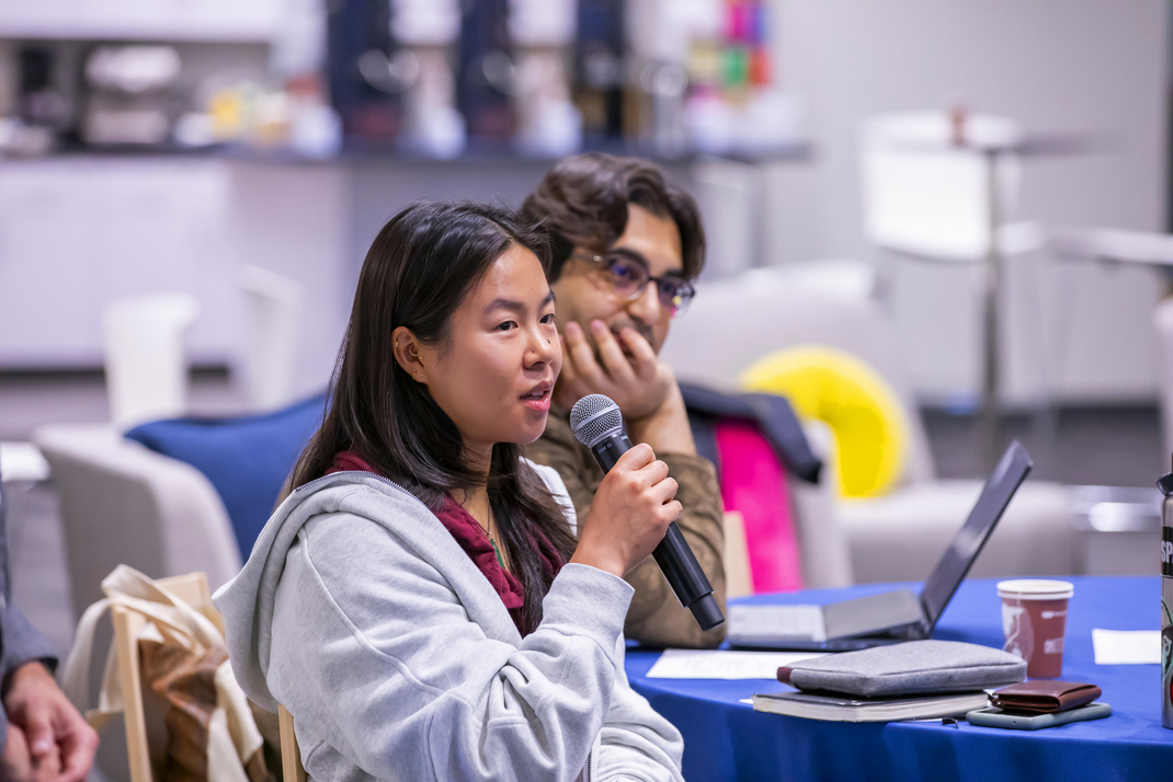 A participant in the workshop speaks into a microphone.