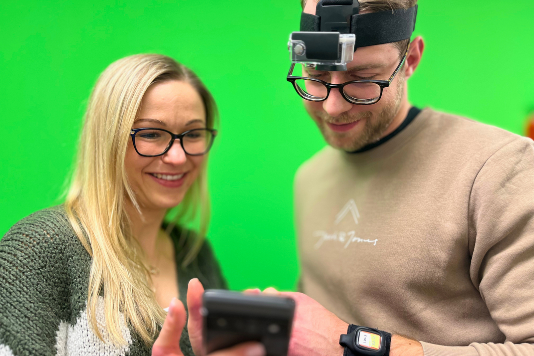 Kristina Kirsten präsentiert einem Probanden die App auf einem Smartphone