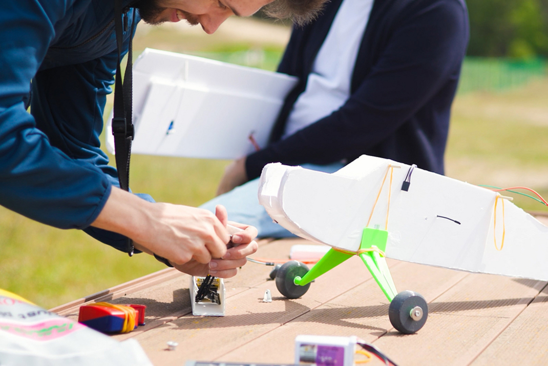 Two people are building a working model airplane.