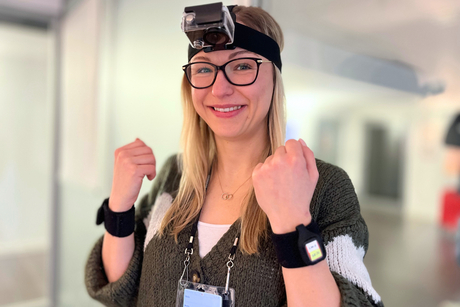 Ph.D.-Kandidatin am HPI Kristina Kirsten präsentiert das System aus Stirnband-Kamera und Bewegungssensoren an den Handgelenken.