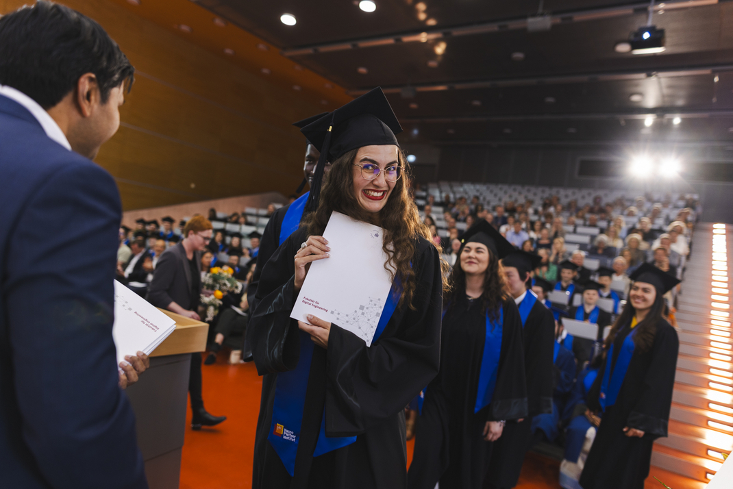 The graduates receive their diplomas one by one