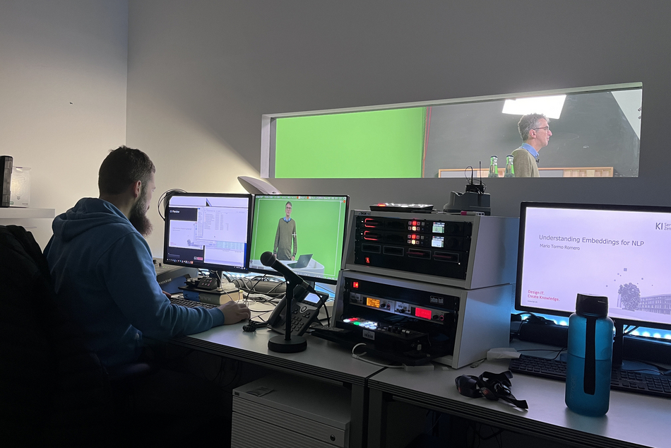 Media technician at a computer, records an online course with an AI expert with a green screen.