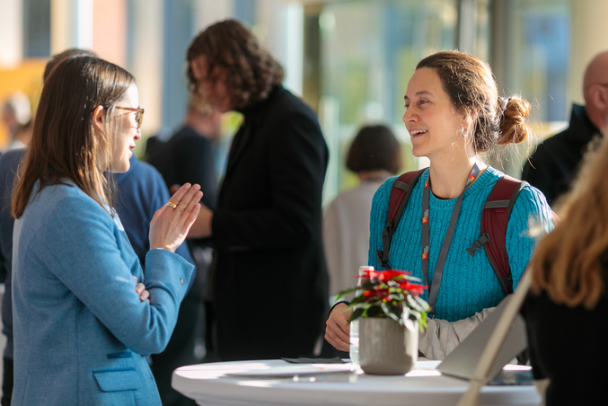 Two people chatting at a bar table during an event