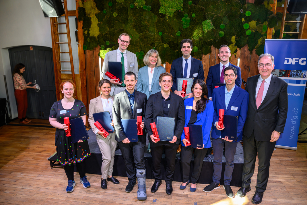 Group photo of the award winners and members of the DFG. The award recipients are holding their certificates.