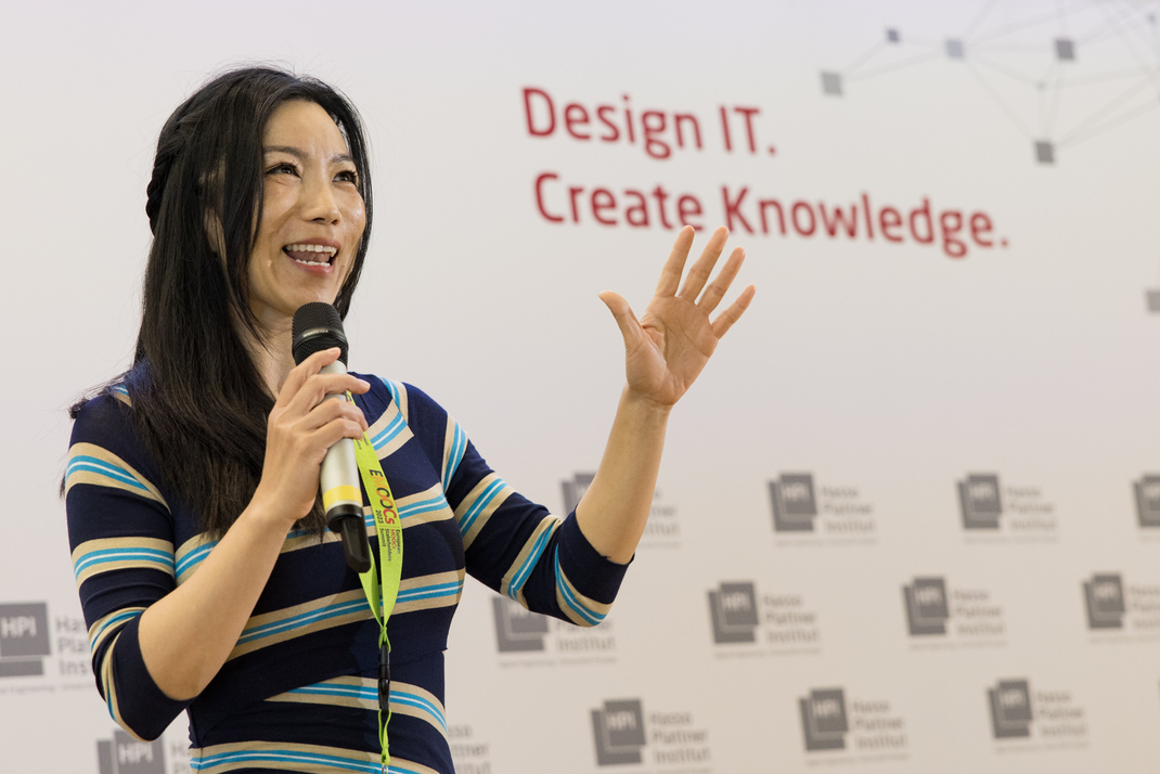 Eine Person hält einen Vortrag. Auf der Wand hinter ihr steht "Design it. Create Knowledge"