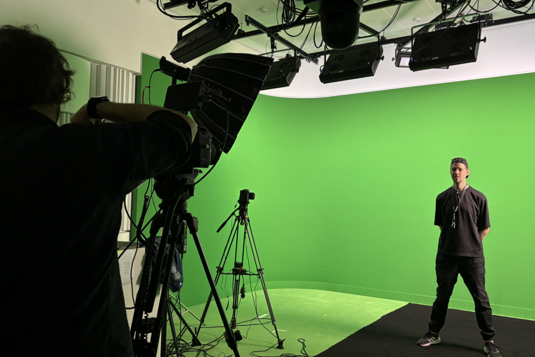 Markus in front of a green screen at the HPI Maker Universe studio.