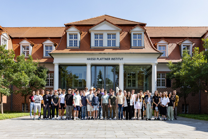 Participants of the HPI Summer Camp 2024 stand in a rectangle in front of the HPI villa