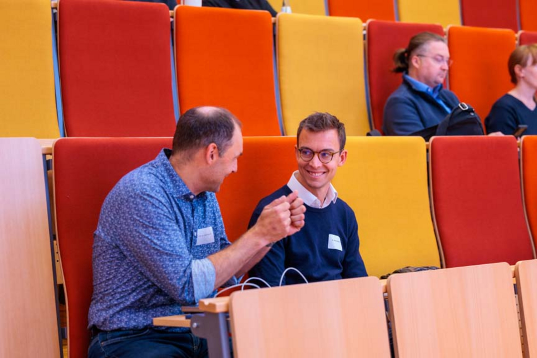 Ralf Herbrich unterhält sich im Auditorium mit einer anderen teilnehmenden Person