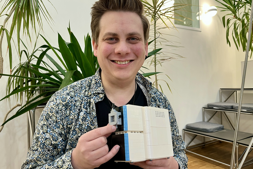 Dr. Christoph Schlaffner hält ein aus Lego gebautes Massenspektrometer in der Hand