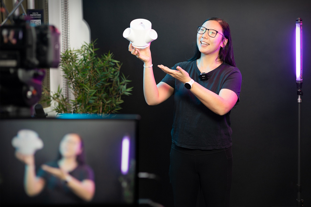 A person presents a prototype made of white plastic.