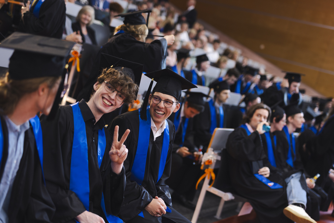 The photo shows proud graduates in the audience
