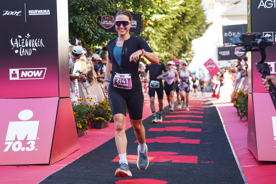 Caterina Mandel runs through a gate during a triathlon