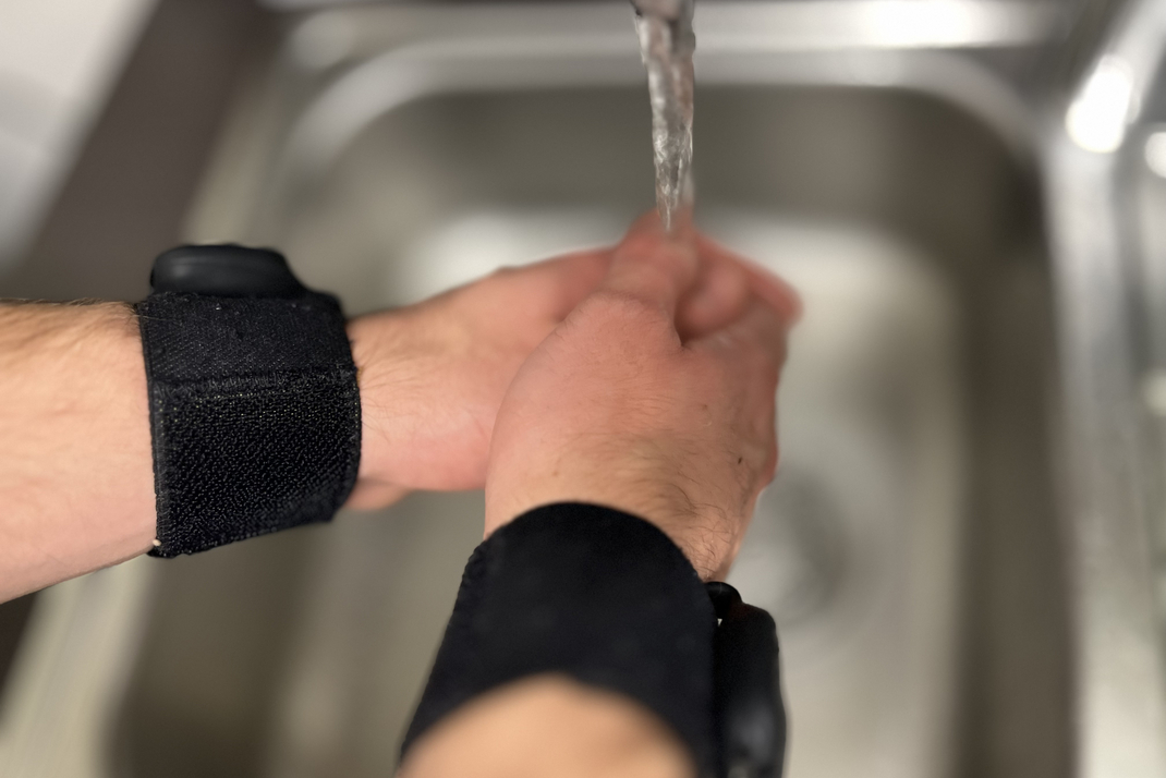 Eine Versuchsperson wäscht sich die Hände, während an ihren Handgelenken Sensoren angebracht sind